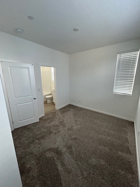 an empty room with a carpeted floor and a white door