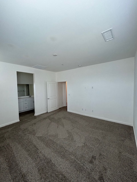 an empty living room with carpet and white walls