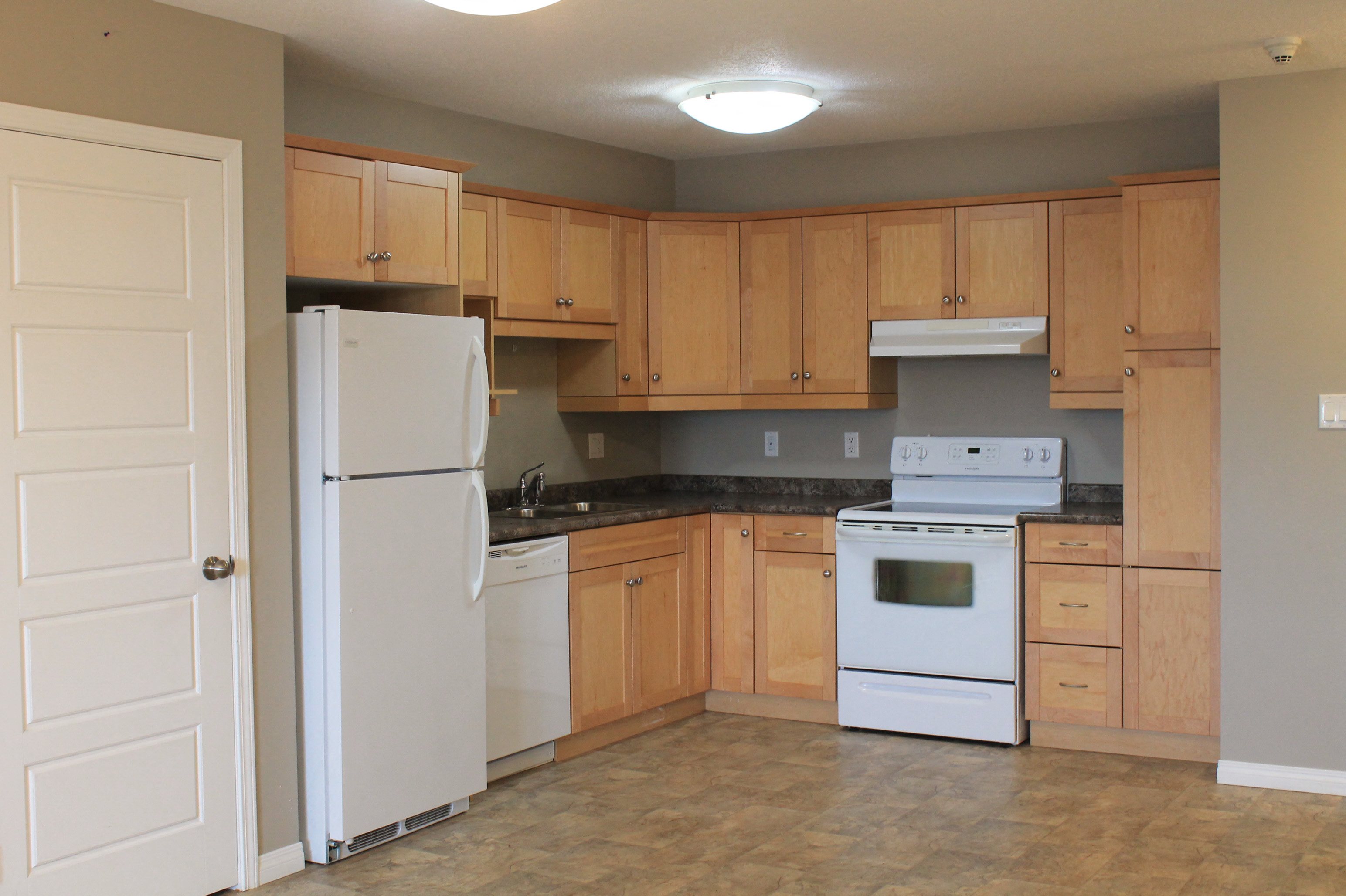 a kitchen with white appliances and wooden cabinets