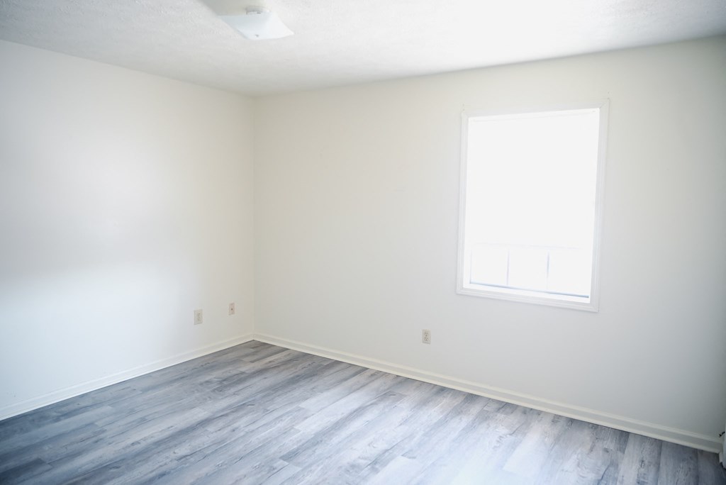 an empty room with white walls and a window