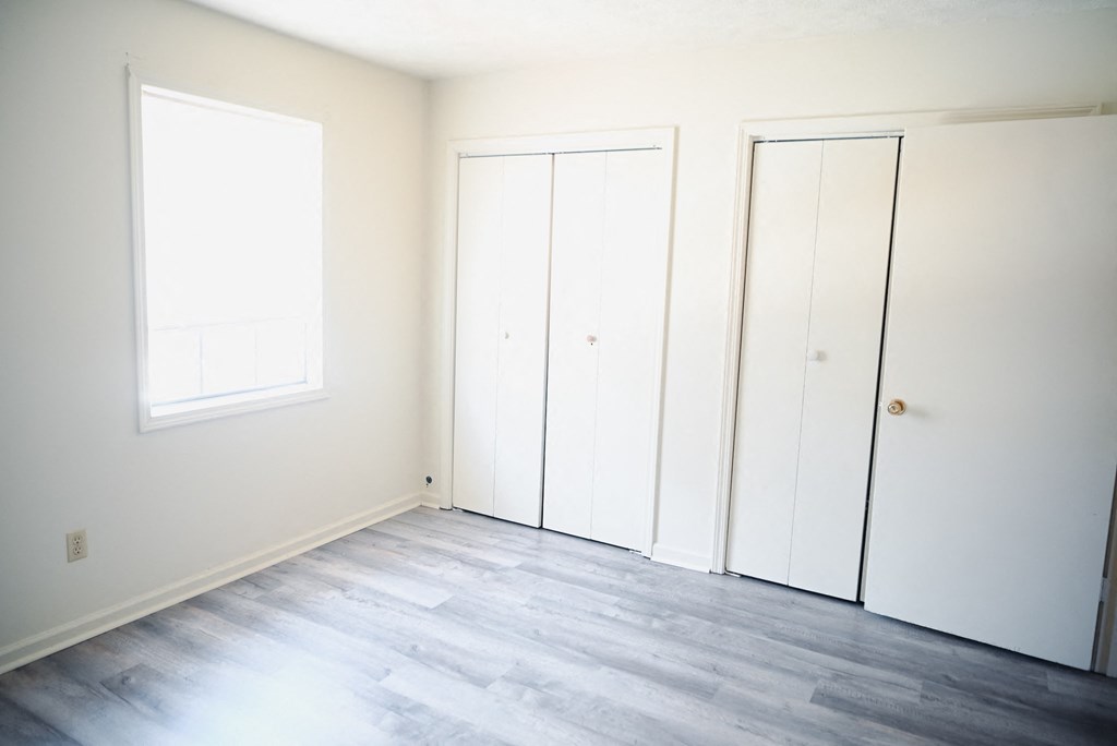 an empty room with white walls and two doors