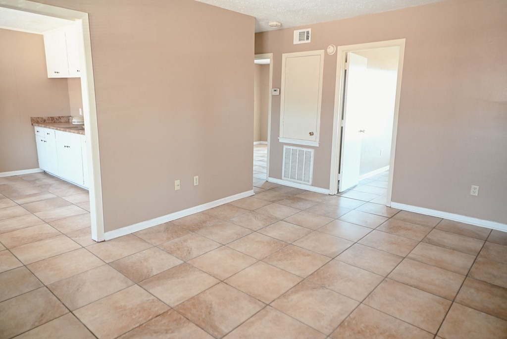 an empty kitchen and living room with tile flooring