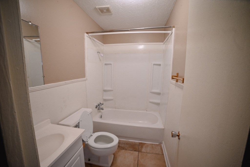 a bathroom with a toilet and a tub and a sink