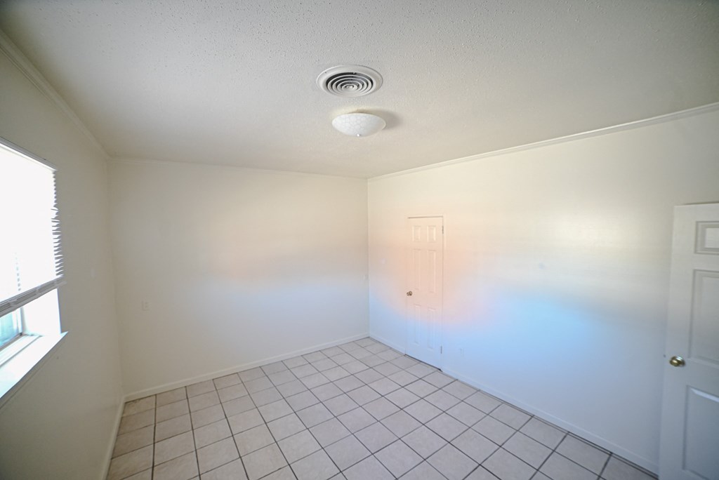 an empty room with white walls and a white tile floor