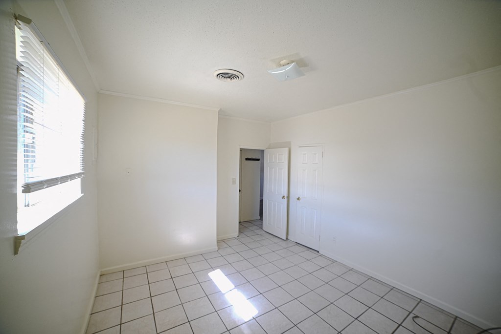 an empty living room with white walls and a window