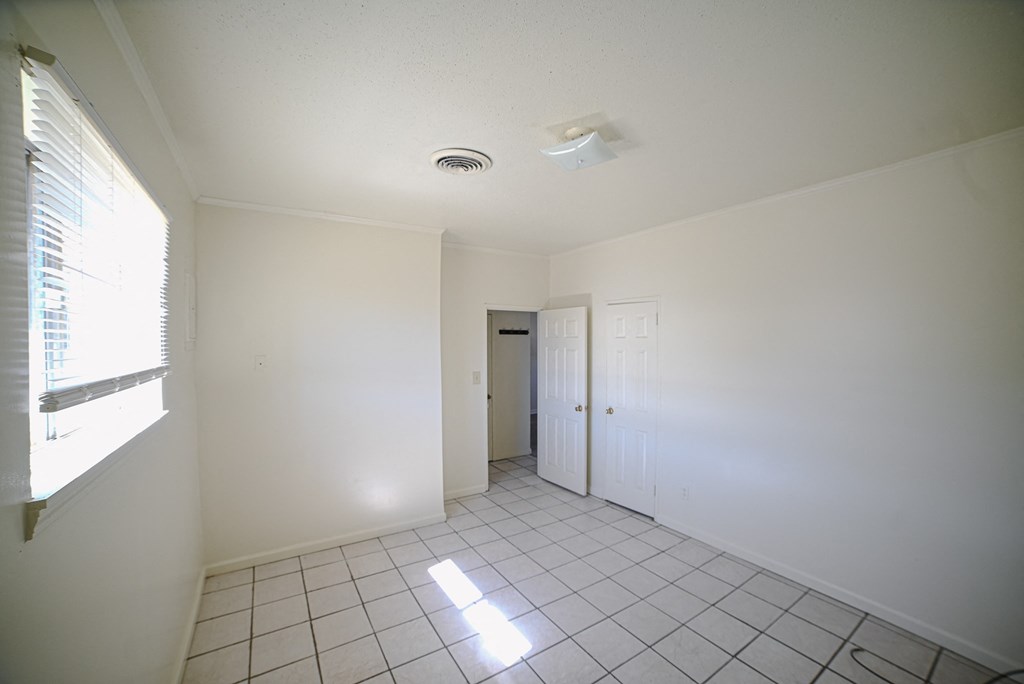 an empty living room with white walls and a window