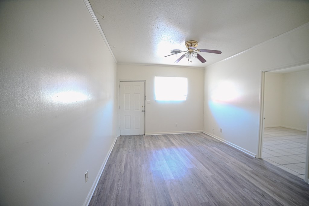 the living room of an empty house with a ceiling fan