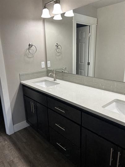 A bathroom with a white sink and black drawers.
