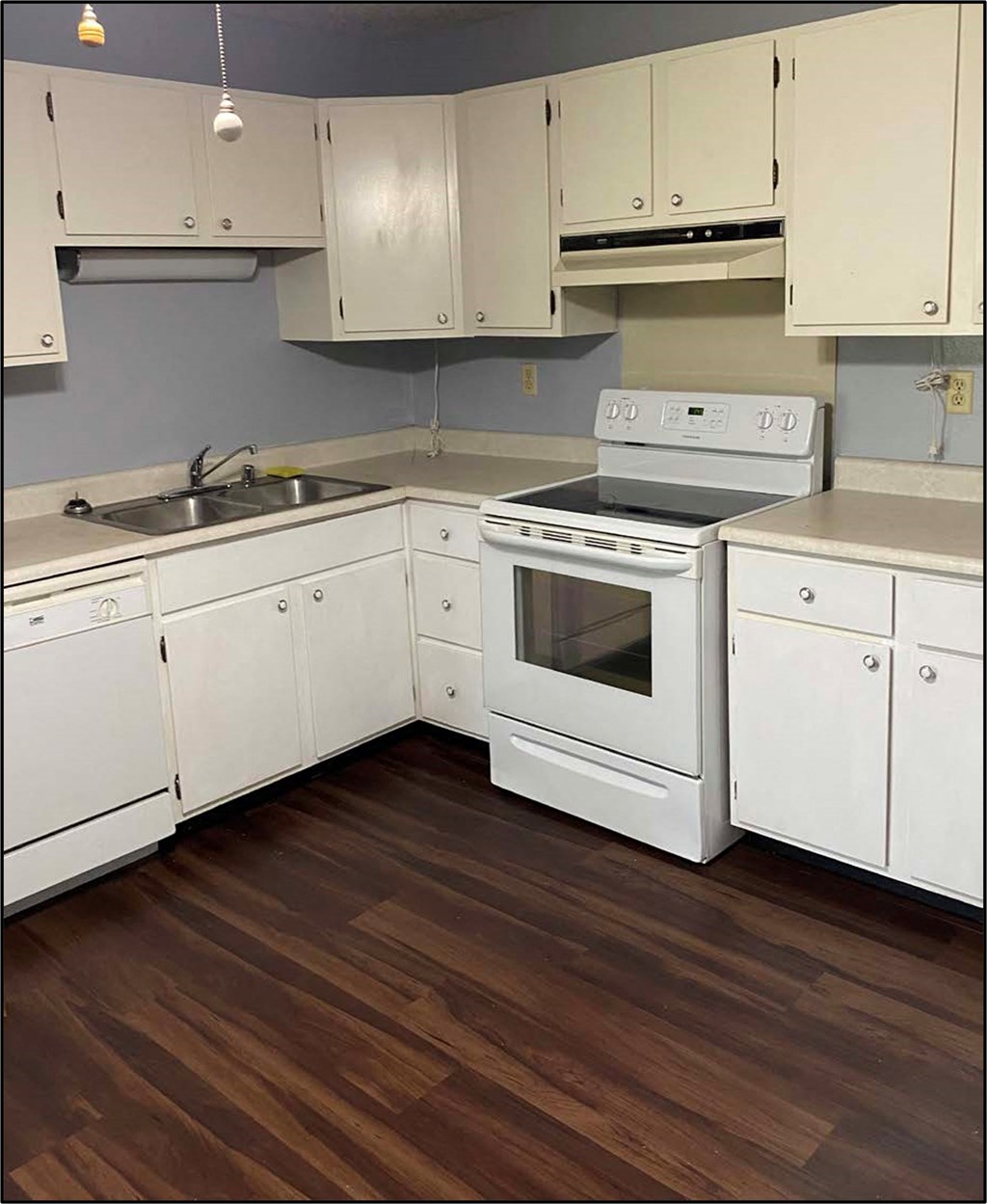 a kitchen with white cabinets and a stove and a sink