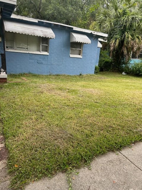 a blue house with a lawn in front of it