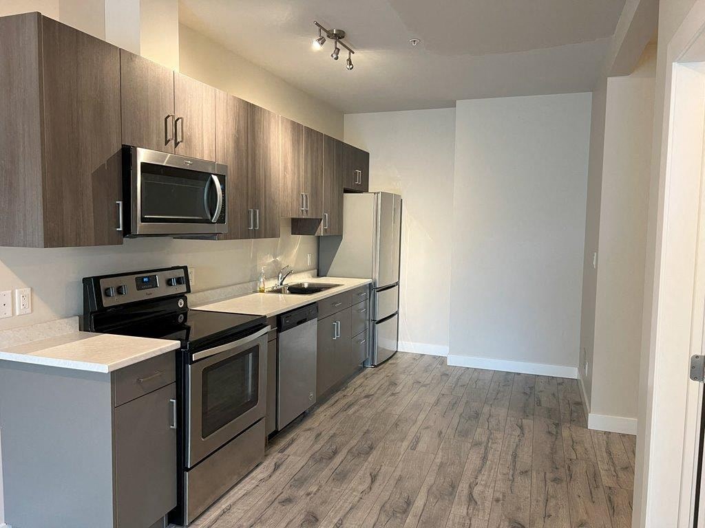 a kitchen with stainless steel appliances and a microwave