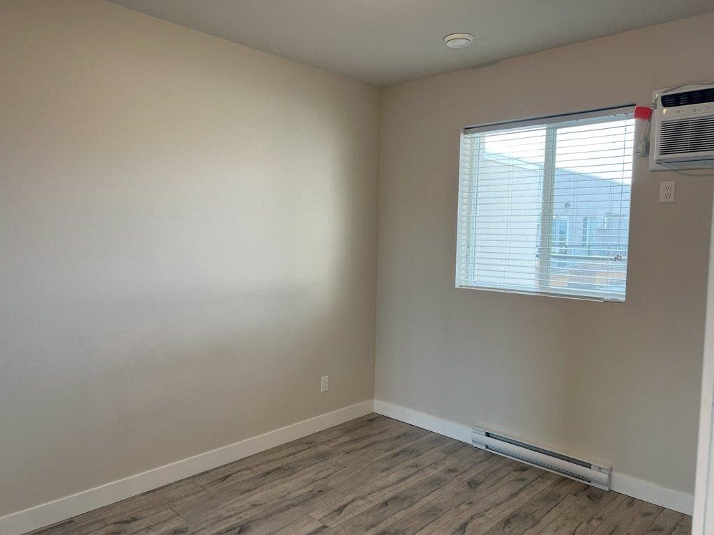 an empty room with a window and a air conditioner