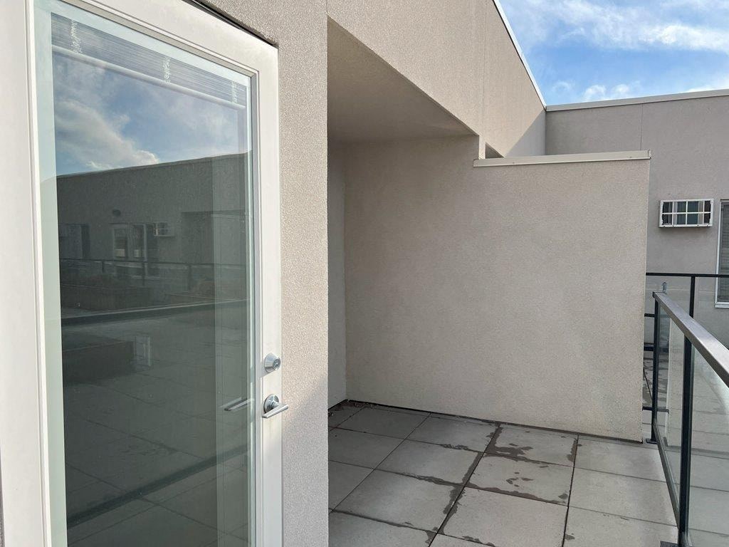 a balcony with a glass door and a patio