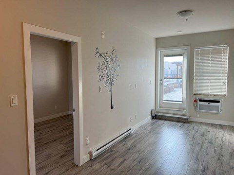 a living room with a hard wood floor and a window