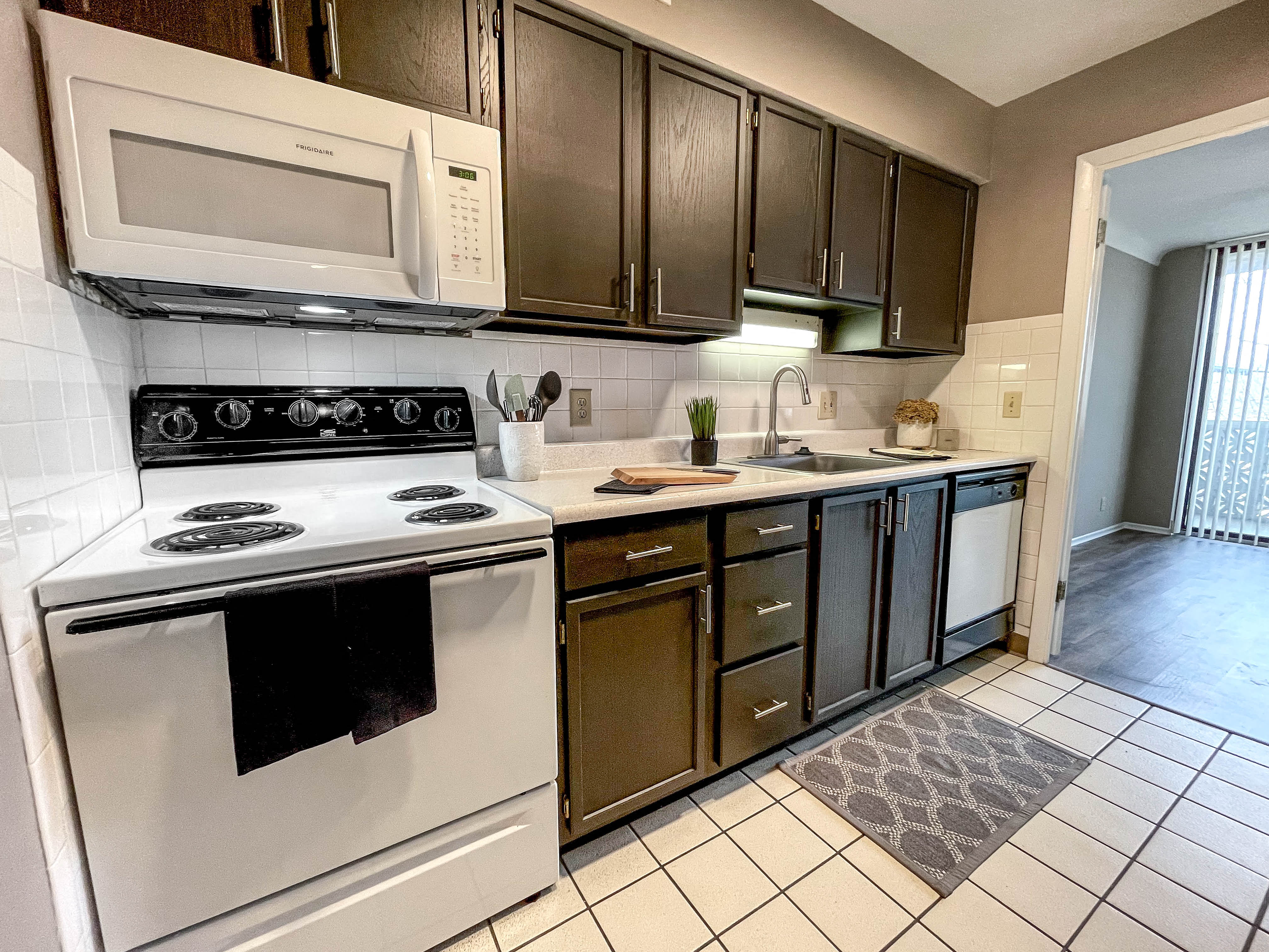 a kitchen with white appliances and dark cabinets