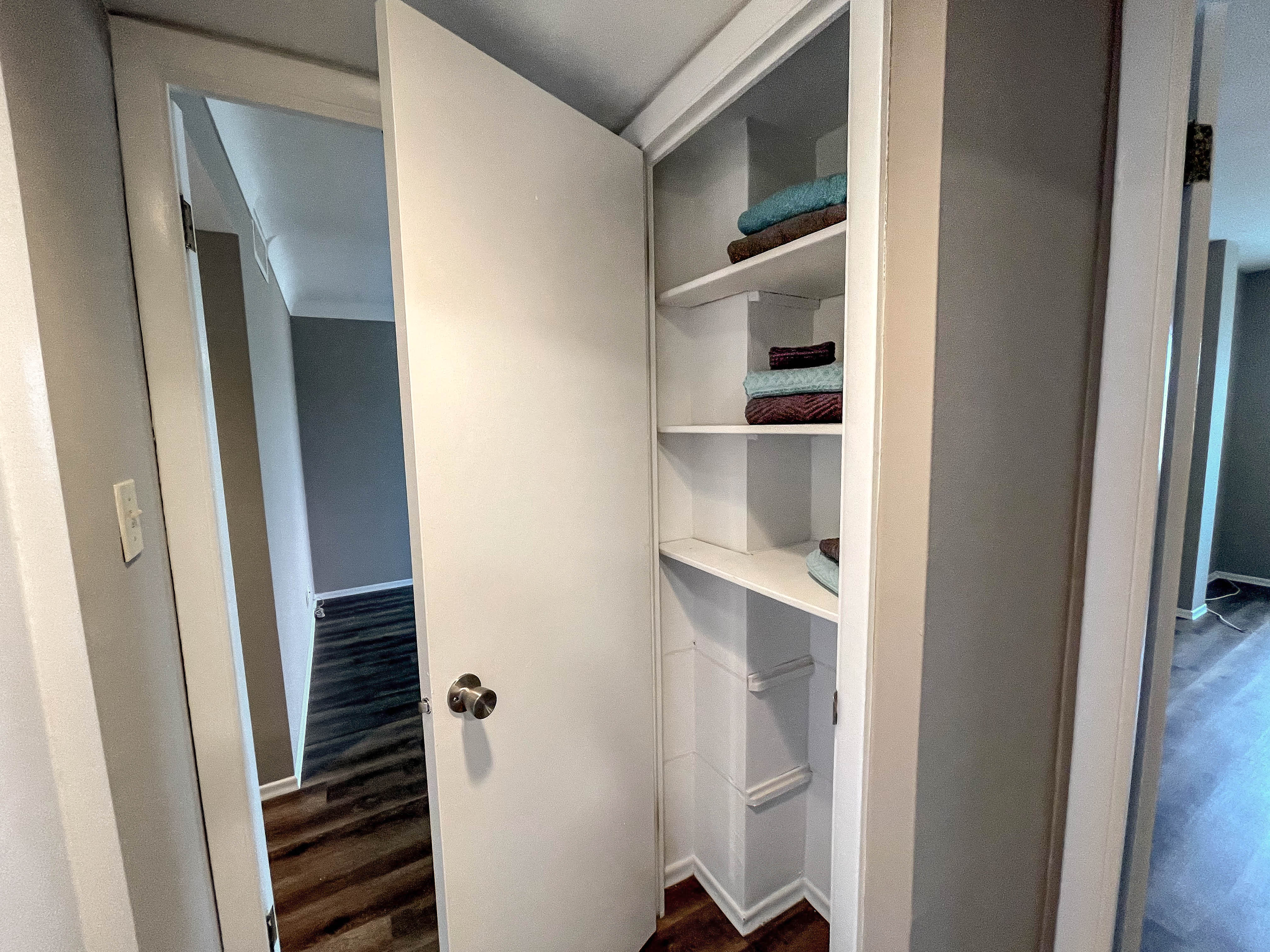 a large white closet with shelves and a door