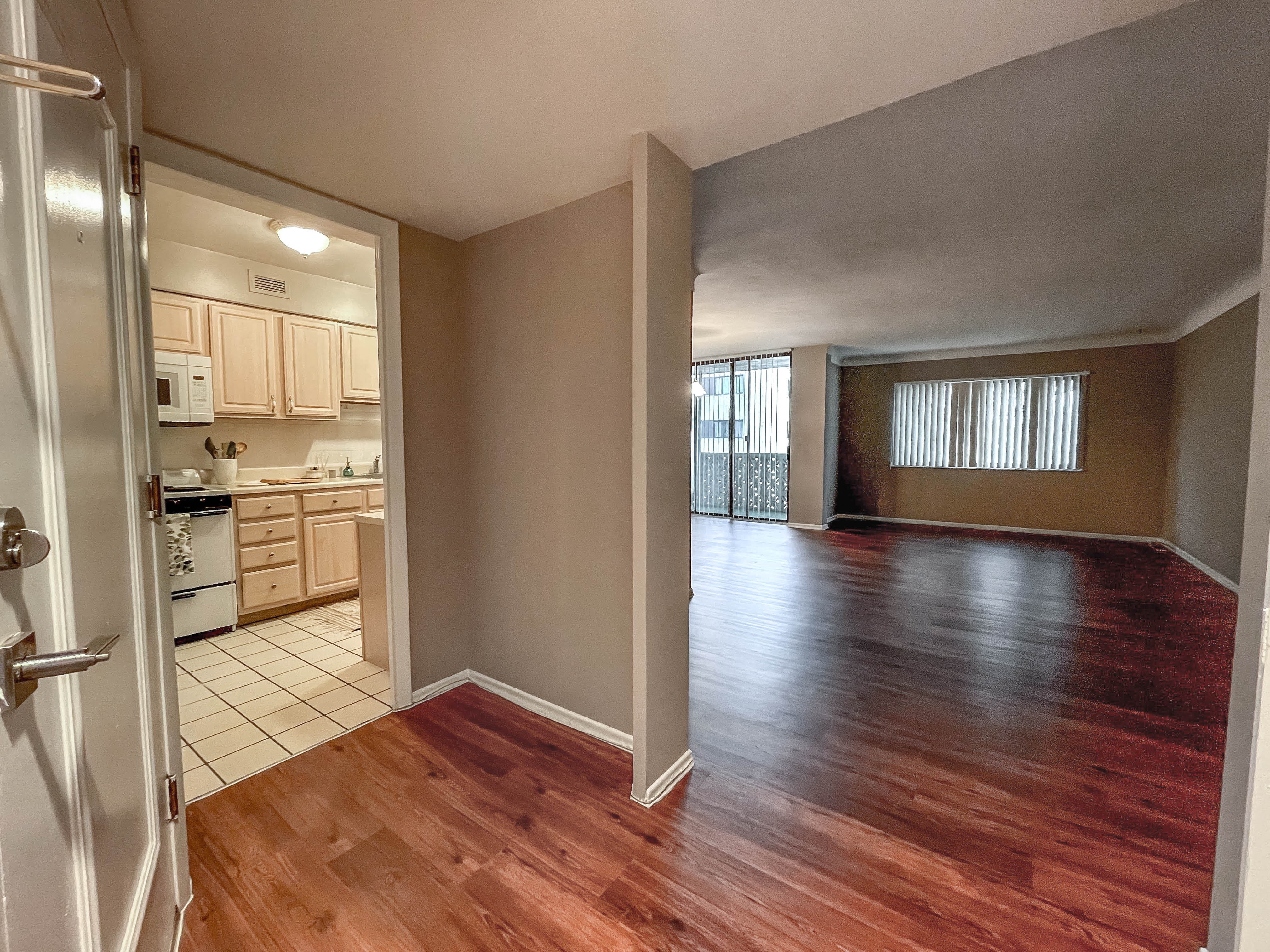 a view of a living room and kitchen with wood floors