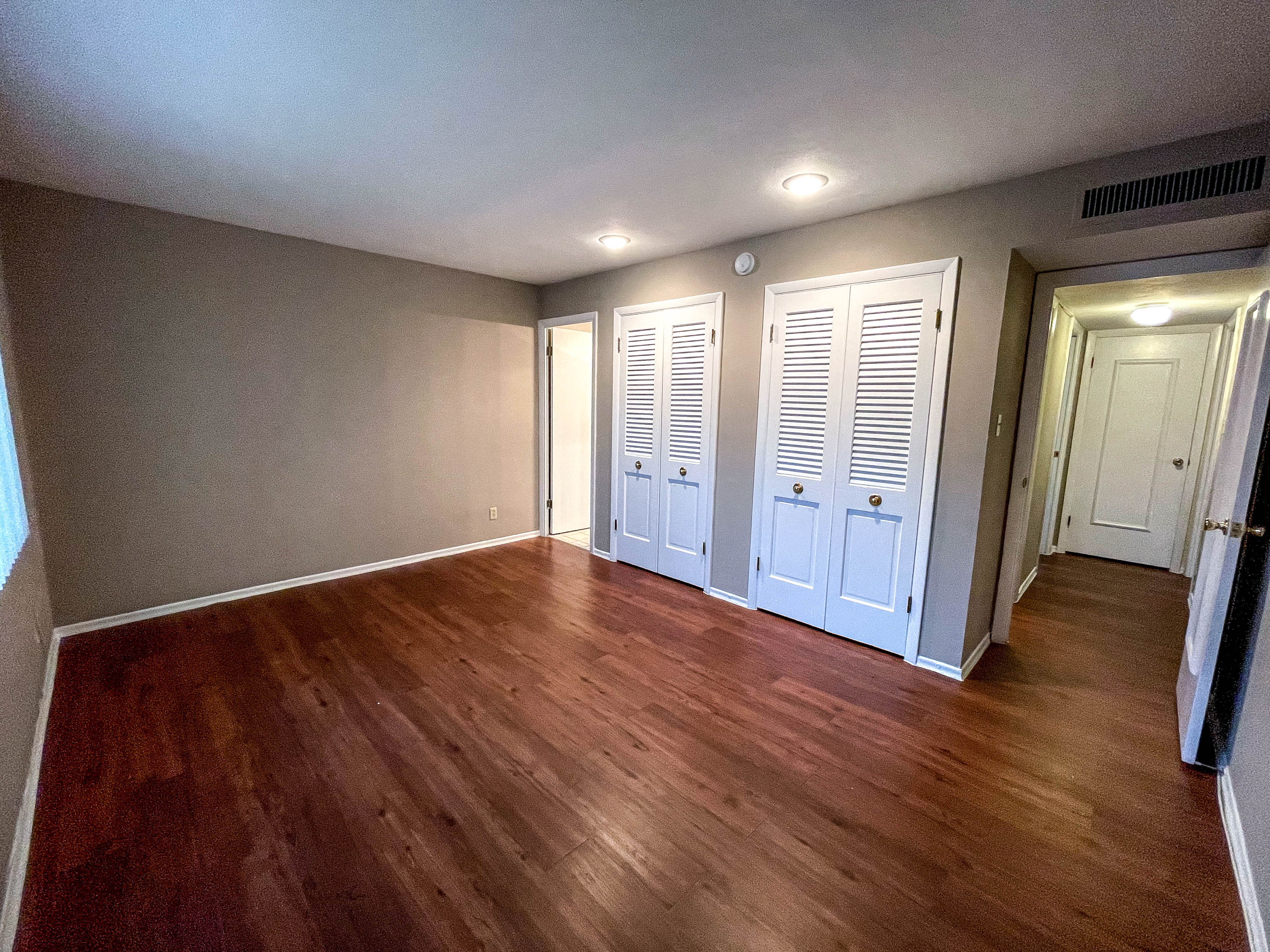 a living room with wood floors and white doors