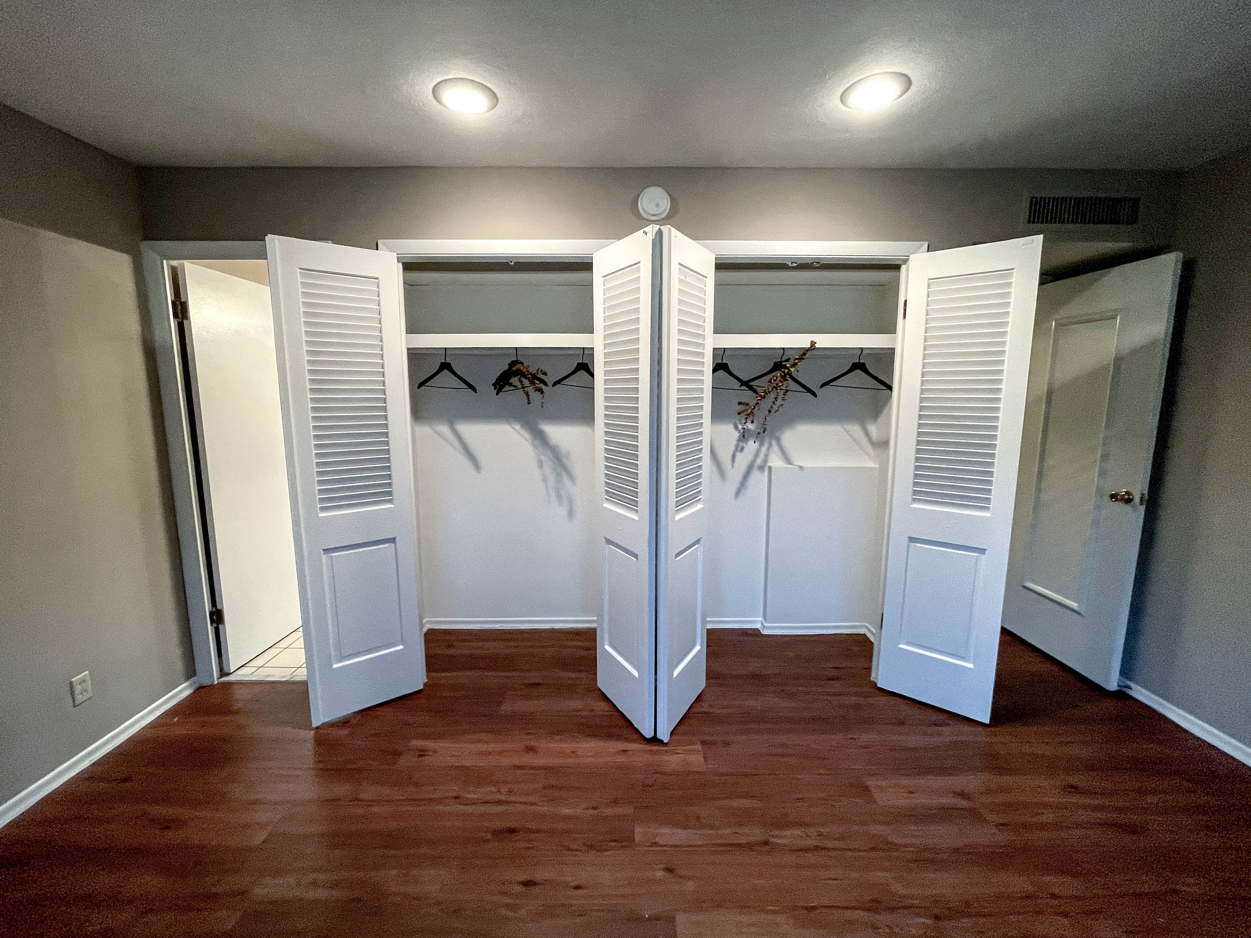a room with closet doors and a wood floor