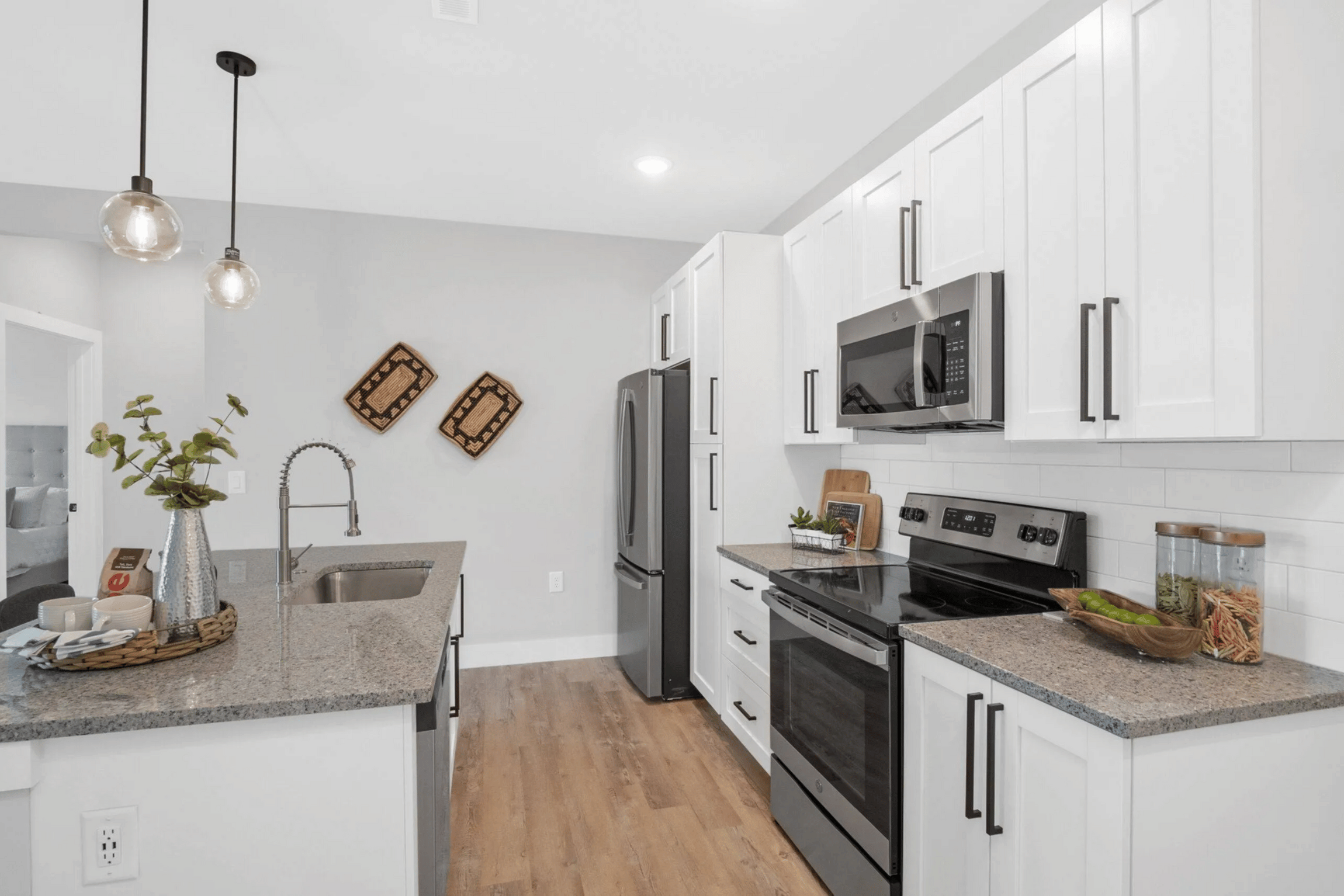 A kitchen with white cabinets and a granite countertop.