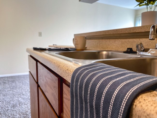 a kitchen with a sink and a counter with a towel on it