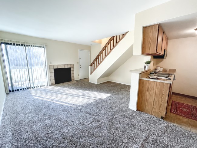 the view of a living room and a staircase in an apartment