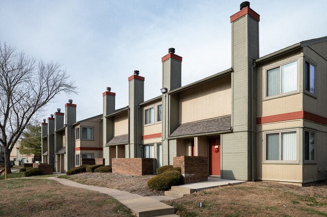a row of townhomes with chimneys on the side of the building