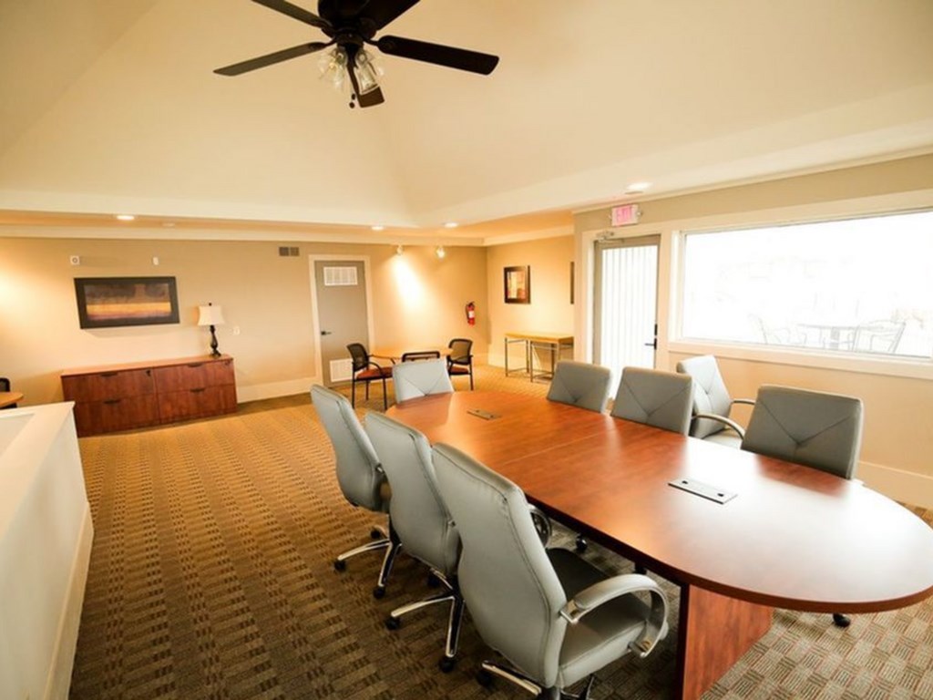 a conference room with a large wooden table and chairs