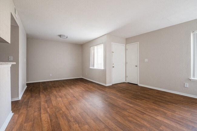 the living room of an empty house with wood flooring