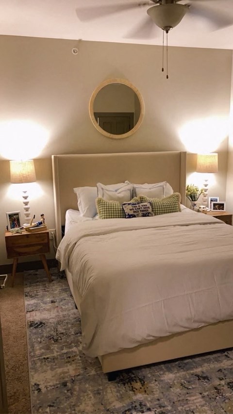 a bedroom with a white bed and a mirror on the wall