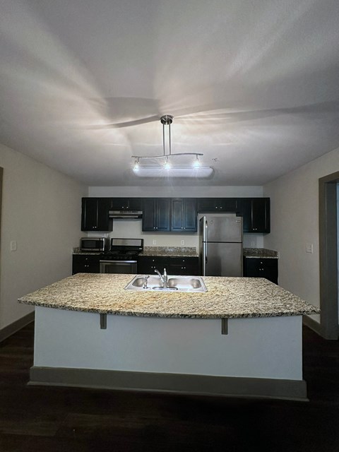 an empty kitchen with a granite counter top
