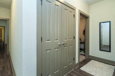a hallway with two closet doors and a mirror