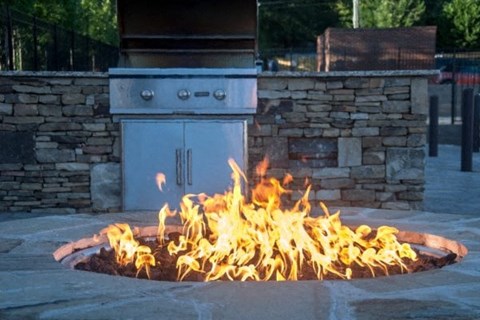 a fire pit with a stove in the background