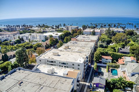 A view of a city with buildings and a body of water in the distance.