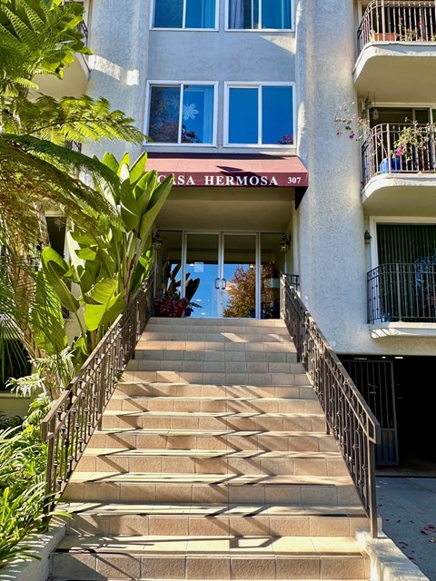 A staircase leading to a building with the sign "Casa Hermosa 307" on it.