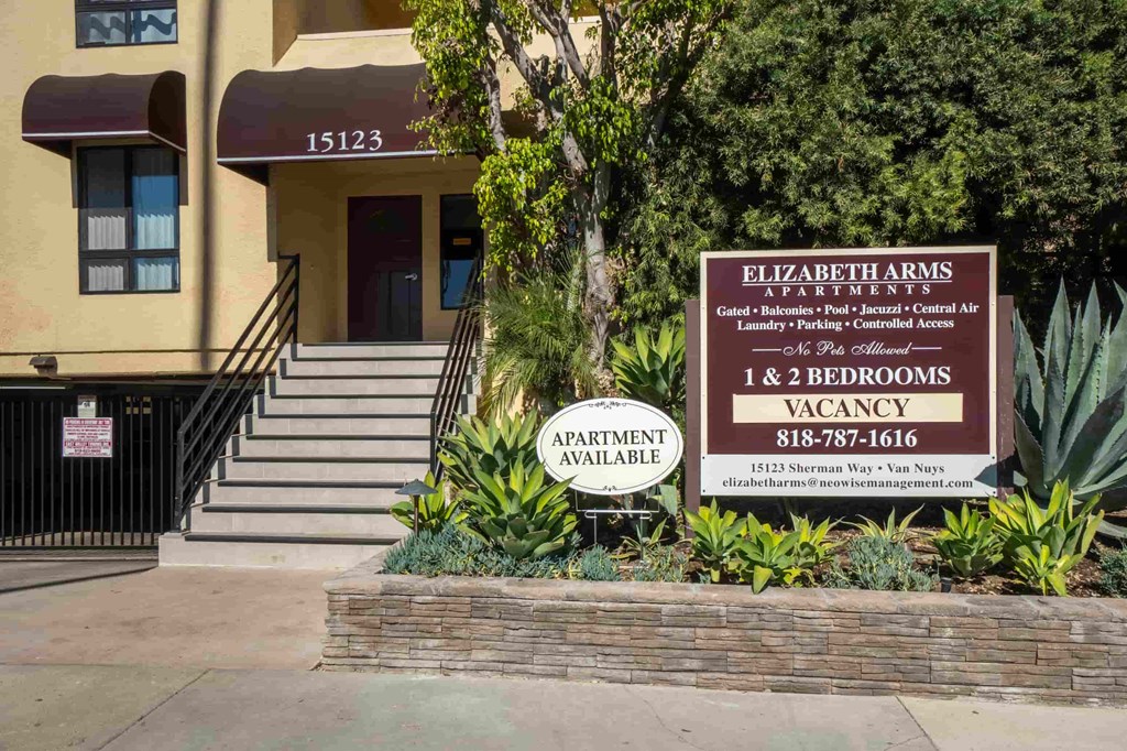 A sign for Elizabeth Arms Apartments is displayed in front of a building.