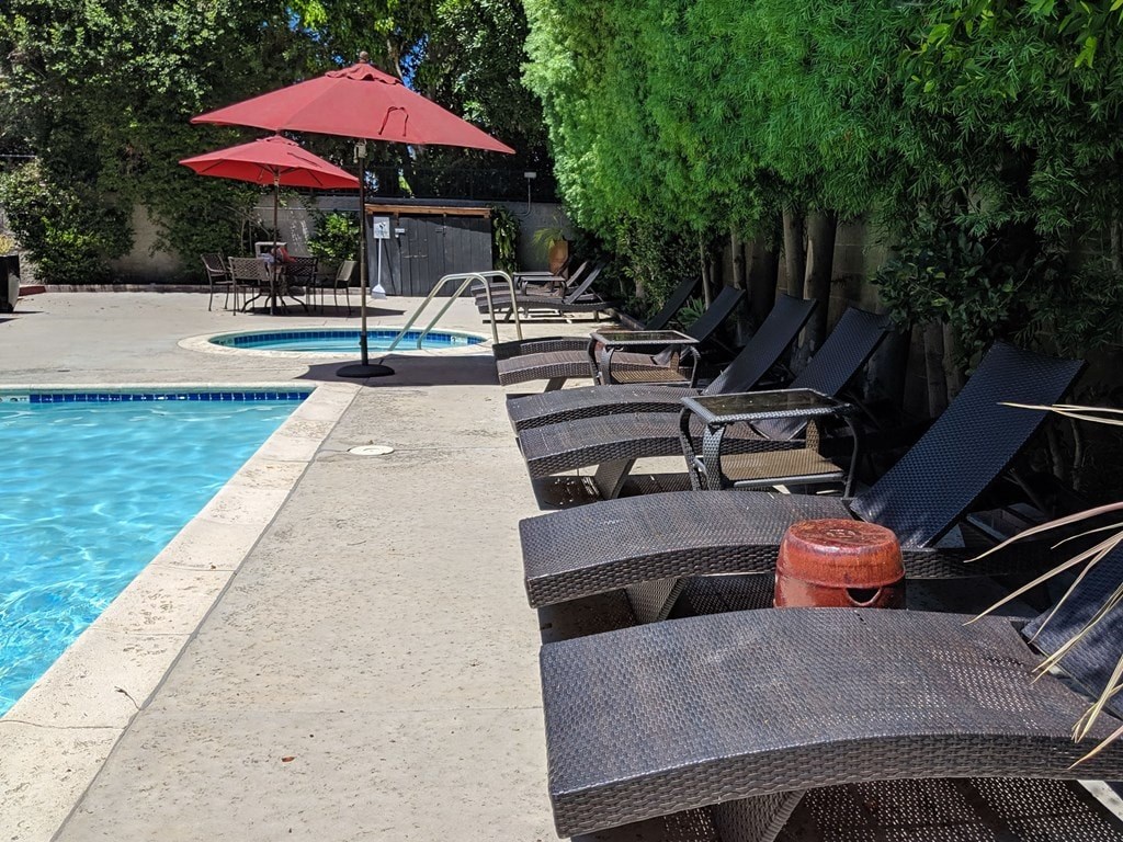A poolside area with lounge chairs and umbrellas.