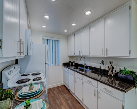 a kitchen with white cabinets and a counter top and a sink