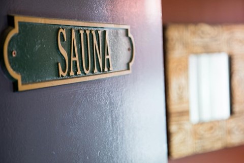 A Sauna sign is mounted on a wall.
