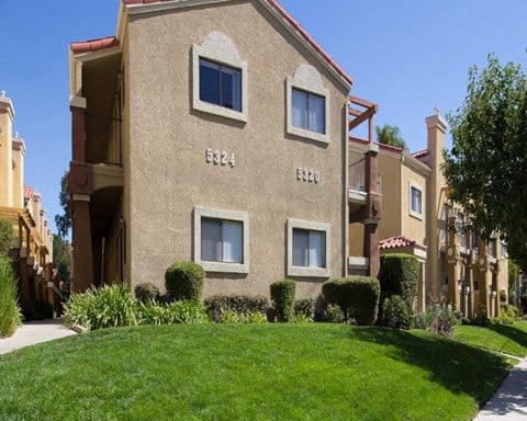 an apartment building with a lawn in front of it