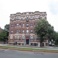 A large red brick building with a black door and windows.
