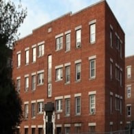 A tall red brick building with many windows.