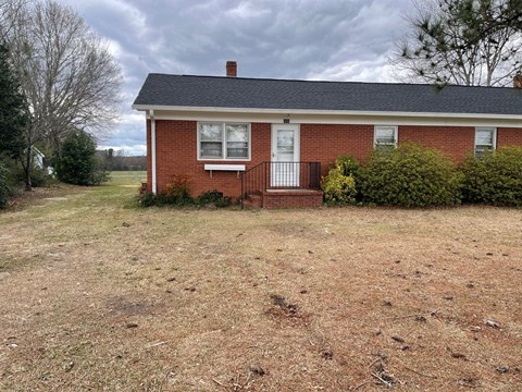 a brick house with a yard in front of it