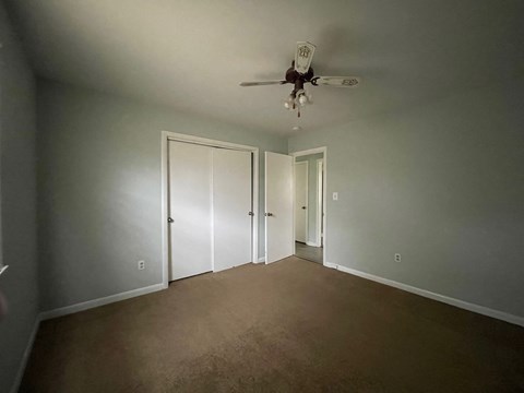 a empty living room with a ceiling fan