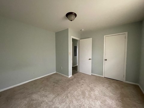 a empty living room with gray walls and a carpet