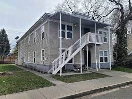 a gray house with a white porch and stairs