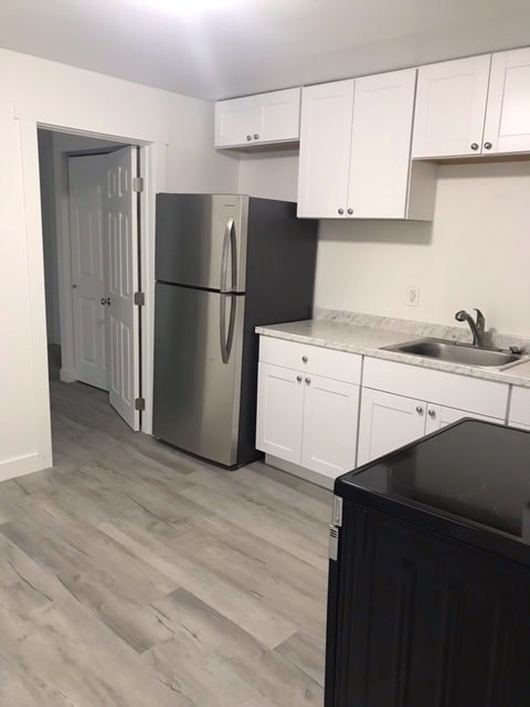 A kitchen with a black counter top and white cabinets.