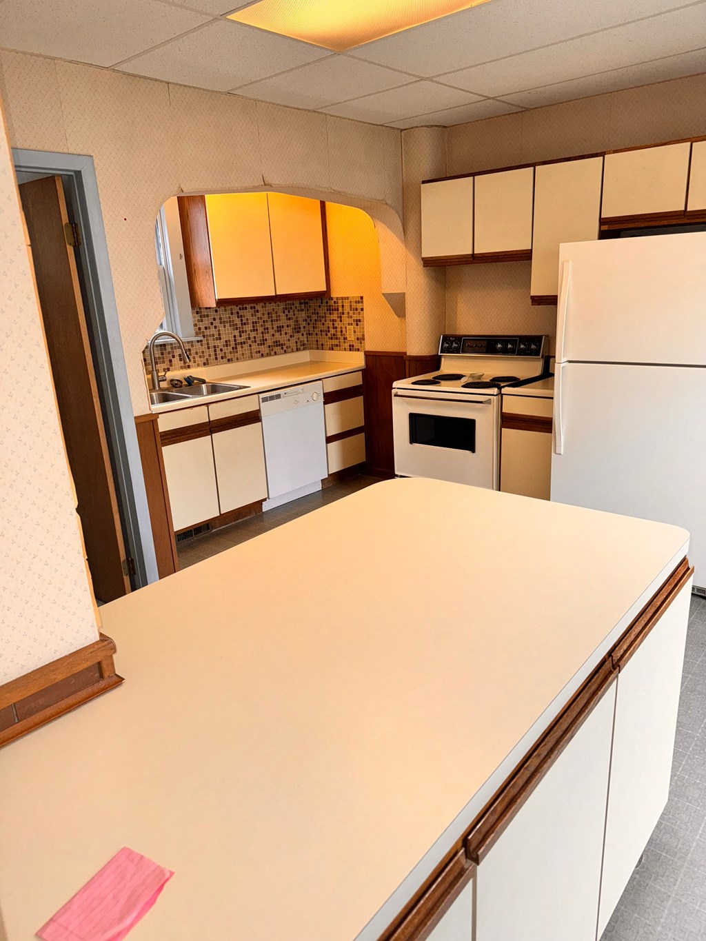 a kitchen with a white counter top and white appliances