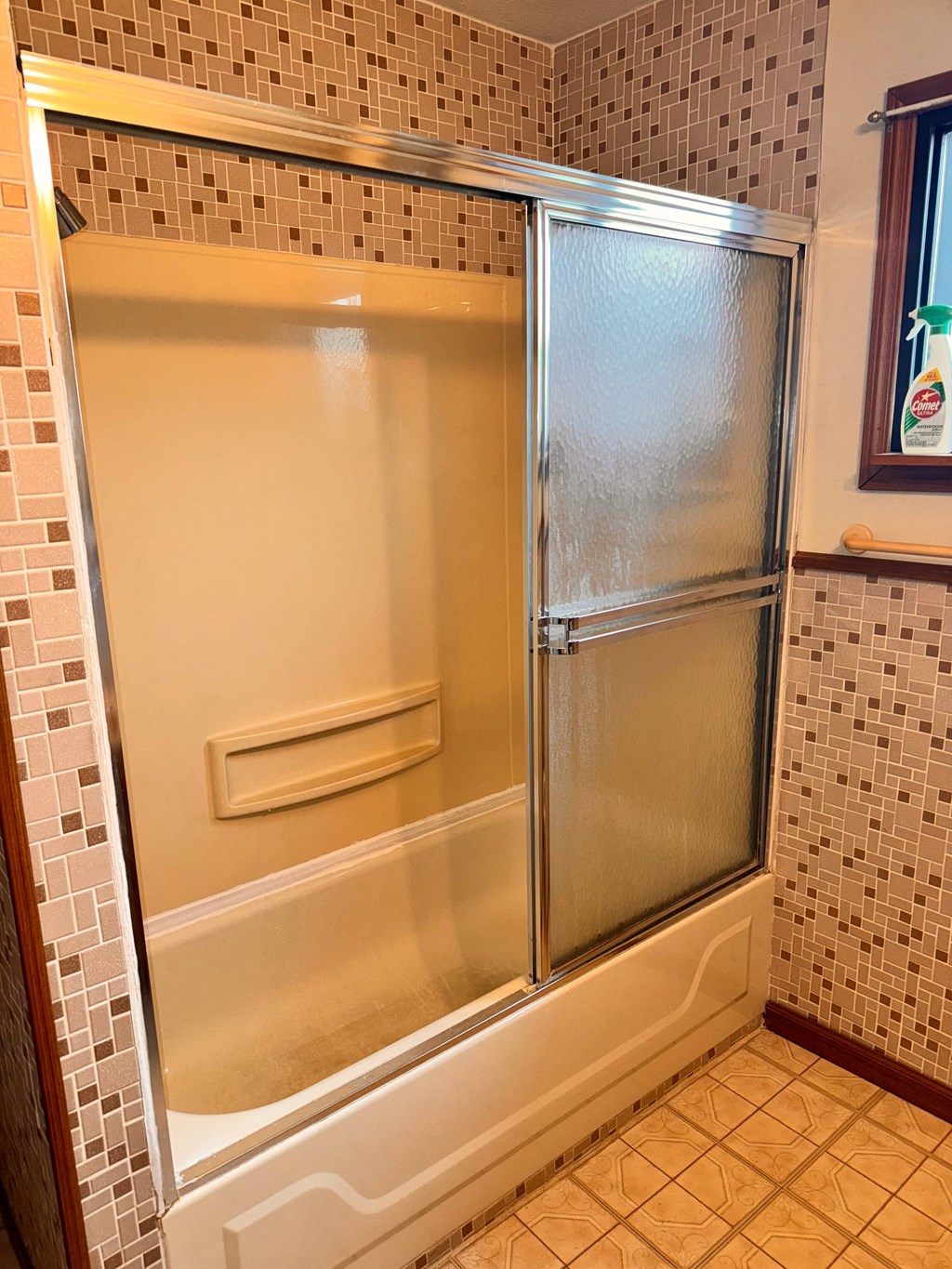 a shower with a sliding glass door in a bathroom