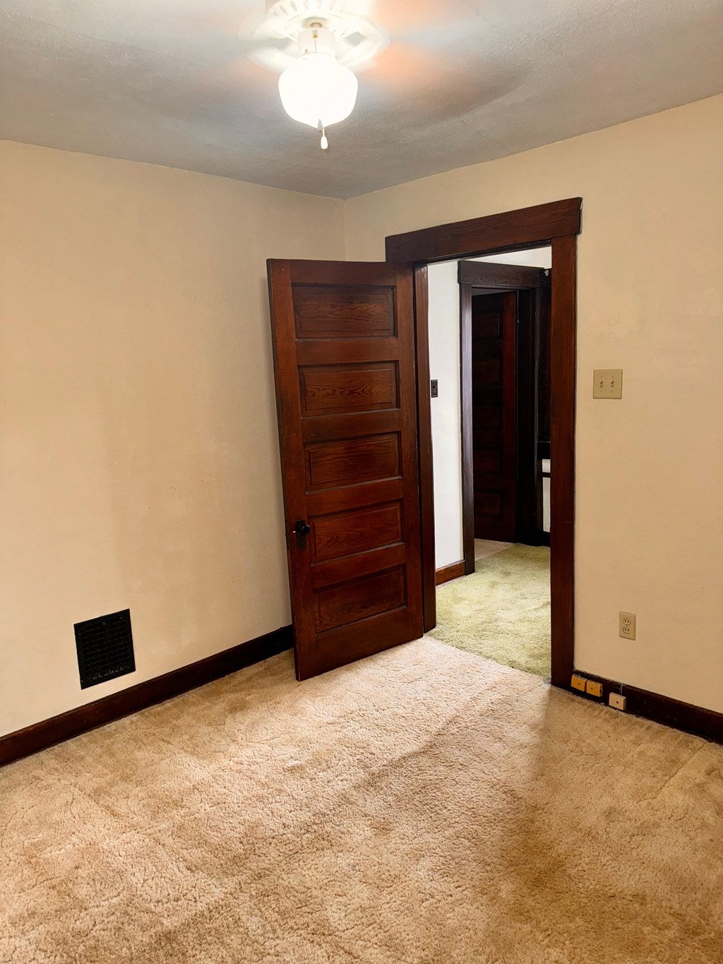 a room with a door and a carpeted floor